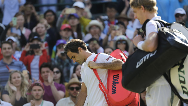 Roger Federer (left) leaves the court after losing his Wimbledon quarter-final match against Kevin Anderson .