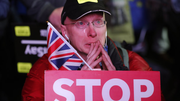 An anti-Brexit demonstrator cries at a rally in Parliament Square in London.