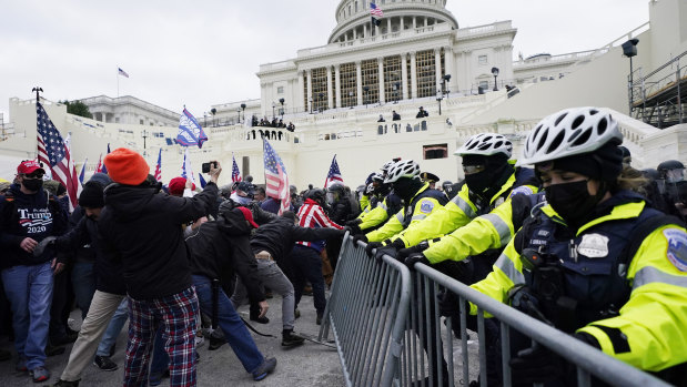 Trump supporters try to break through a police barrier outside the US Capitol in Washington DC.