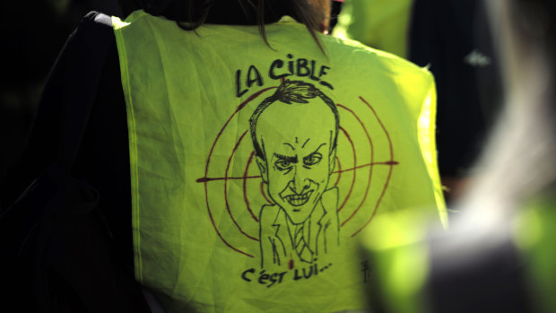 A protester wears a a yellow vest with a drawing depicting French President Emmanuel Macron and the word "target" during a demonstration in the streets of Paris, France, on Saturday.