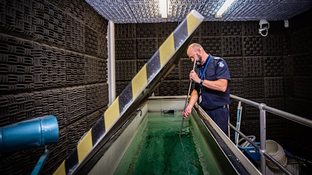 Senior Sergeant Steve Farrar with the ballistic tank at Victoria Police Forensic Services Centre.