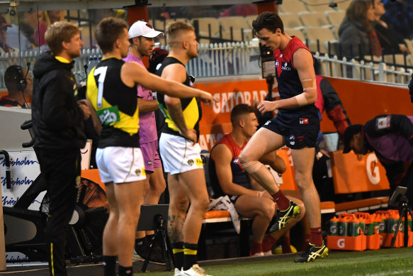 Jake Lever of the Demons (right) is seen after sustaining an injury.