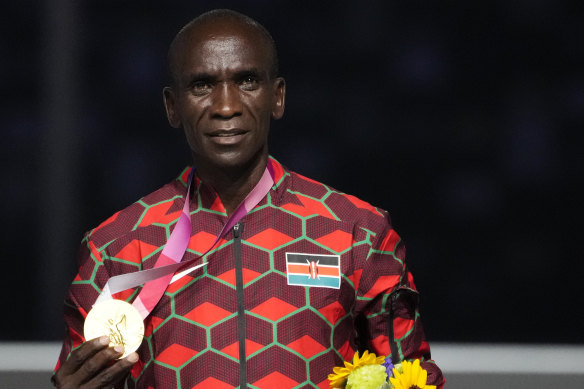Kipchoge poses with the Olympic gold medal in 2021.