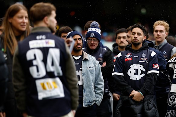 Teammates from local club Epping stand in honour of Nathan Fitzgerald before Richmond plays Melbourne at the MCG.