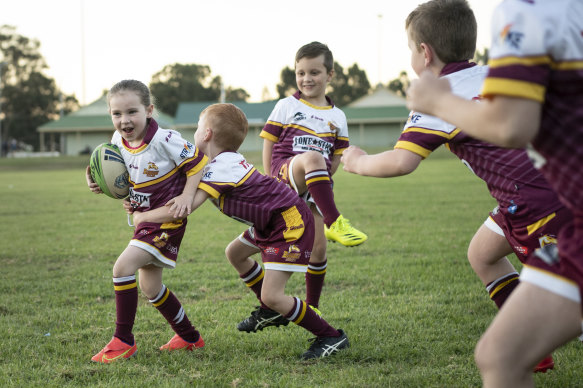 Mackenna Crowe (Glenmore Park Brumbies) is tackled by Jack Parker at training, as Oliver Jackson watches on.