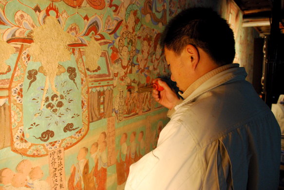                       Çin'in Mogao Mağaraları'ndaki fresklerde restorasyon çalışması.  Konservatör Mağara 15'te çalışıyor.
