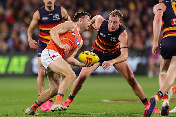 GWS star Toby Greene looks to fire off a handball under pressure from Crows counterpart Jordan Dawson.