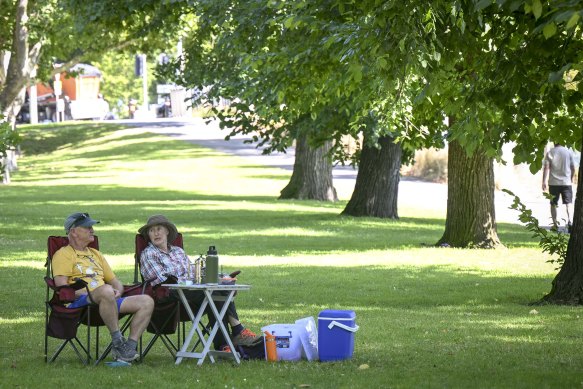 Philip Rance and Linsay Sadler-Dadge enjoy a spot of shade by the Yarra River on Saturday.