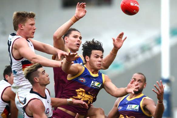 Cam Rayner of the Lions (center) competes for the ball against Adelaide in round 4.