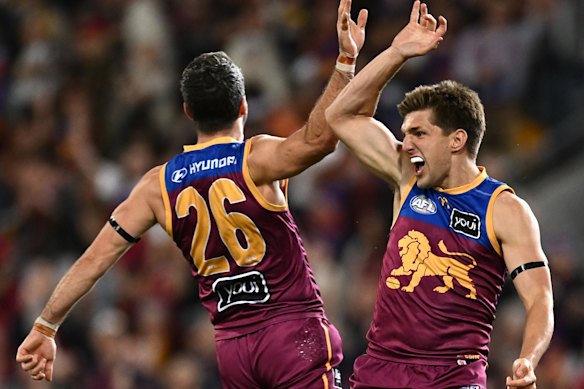 Zac Bailey of the Lions celebrates with Conor McKenna after kicking a goal.