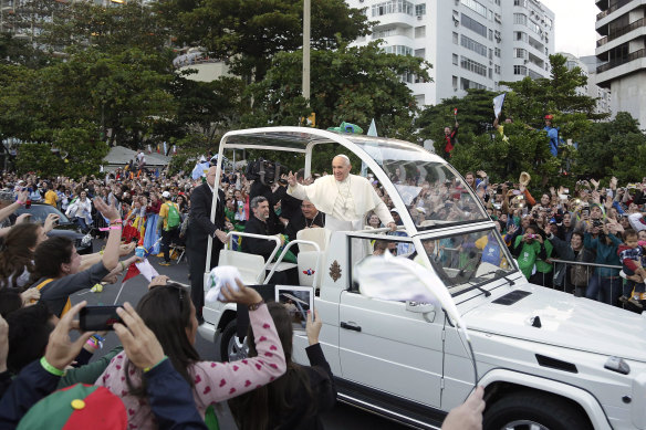 The Pope waves to people from his popemobile along the Copacabana beachfront in Rio de Janeiro, Brazil, in 2013. 