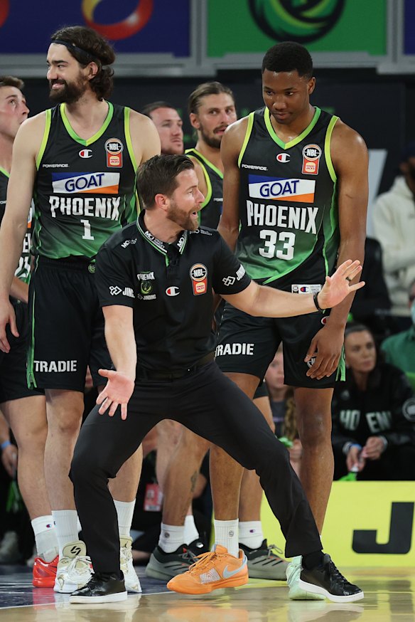 South East Melbourne Phoenix coach Josh King speaks with forward Malique Lewis.
