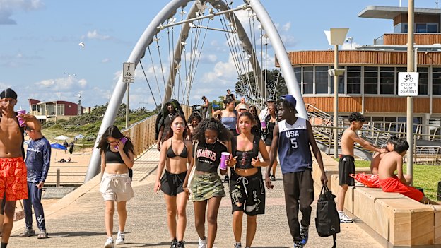 A group of friends cross the Kananook Creek footbridge towards Frankston Pier.