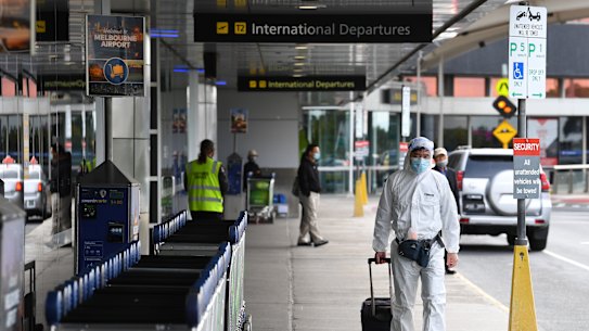 A man in personal protective equipment is seen outside the international departures terminal at Tullamarine Airport, Melbourne.