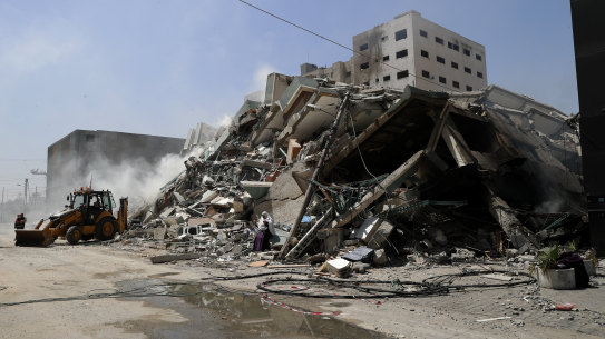 Workers clear the rubble of a building that was destroyed by an Israeli airstrike on Saturday, that housed The Associated Press, broadcaster Al-Jazeera and other media outlets, in Gaza City.