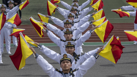 Chinese sailors perform signals with flags at the PLA Navy’s Submarine Academy to mark the navy’s 75th anniversary  in Qingdao, China, on April 21.
