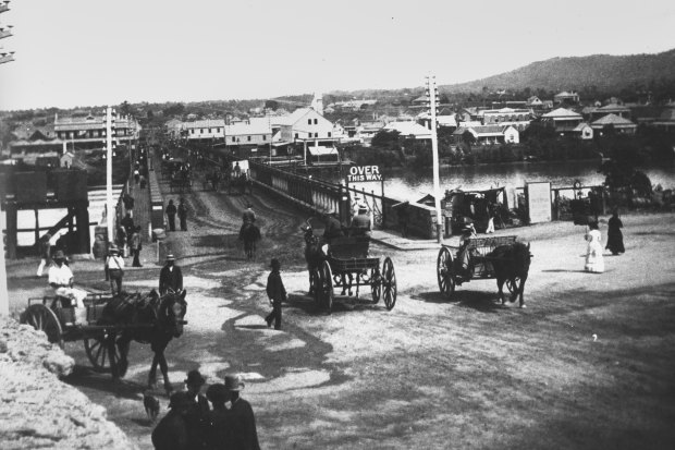 Horse drawn carraiges and pedestrians at the northern approach of the first permanent Victoria Bridge, ca 1885.