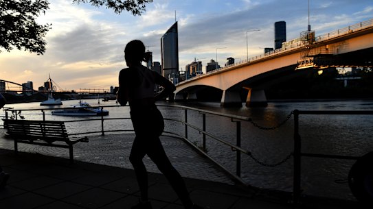 A woman is seen jogging alongside the Brisbane River as the sun sets in Brisbane, Monday, April 27, 2020. The Queensland Government has announced that some restrictions will be eased in Queensland from Saturday, May 2. Queenslanders will be able to go for a drive (within 50km of home), ride a motorbike, jetski or boat for recreation, have a picnic, visit a national park and shop for non-essential items. (AAP Image/Darren England) NO ARCHIVING