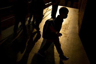 A student arrives as the sun rises during the first day of school in Flint, Michigan. 