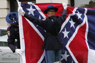 A Mississippi Highway Safety Patrol honour guard folds the retired Mississippi state flag after it was raised over the Capitol grounds one final time in Jackson on July 1.