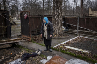 Antonina Pomazanko, 76, shows where she had buried her daughter, Tetiana, after she was killed by Russian fire in Bucha, Ukraine. Pomazanko had covered Tetiana’s body with plastic sheeting and wooden boards (seen beside her).