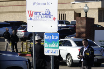An FBI agent stands outside West Freeway Church of Christ as authorities investigate a fatal shooting at the church.