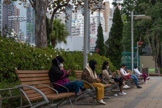 Жители в масках используют смартфоны в парке Виктория в Гонконге, где чиновники здравоохранения предупредили жителей города. 