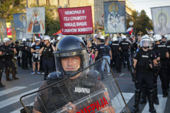 Serbian riot policemen prevent anti-gay protesters, seen holding religious banners in the background, from clashing with participants in the annual gay pride march in Belgrade, Serbia. 