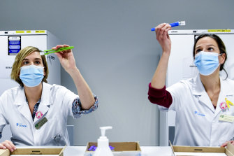 Health workers in Belgium inspect vials of the Pfizer-BioNTech coronavirus COVID-19 vaccine, which is one of the candidates expected to receive approval in Australia by the end of January.