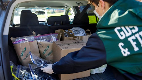 High school student Will Olsen, of Kensington, Maryland, places 3D-printed parts for medical face shields into his car.