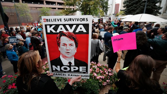 A woman holds a placard during a protest against the nomination of Brett Kavanaugh for the Supreme Court, in Denver, Colorado.