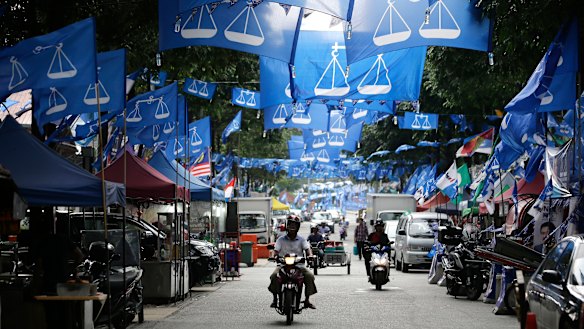 Flags from different political parties hang along a street in Kuala Lumpur.