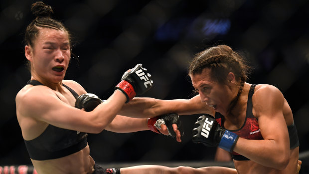 Give and take: Defending champion Weili Zhang trades blows with Joanna Jedrzejczyk during their strawweight contest.
