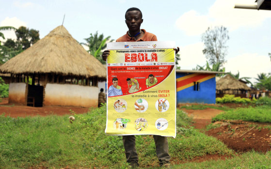 A man displays an Ebola information leaflet in Mangina, Democratic Republic of the Congo.