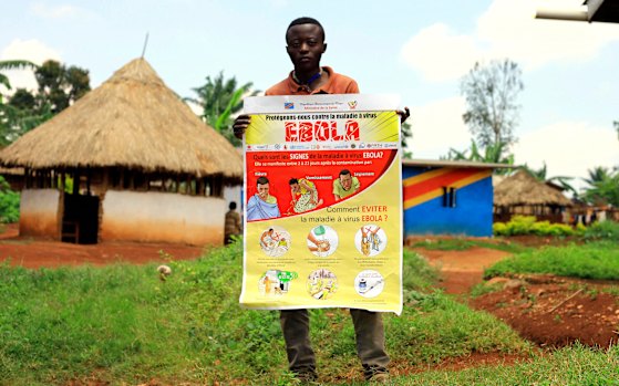 A man displays an Ebola information leaflet in Mangina, Democratic Republic of the Congo.