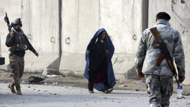 An Afghan woman walks near the site of an attack in Kabul on  January 15.