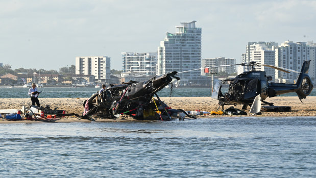 Police inspect a helicopter at the scene of the fatal crash.