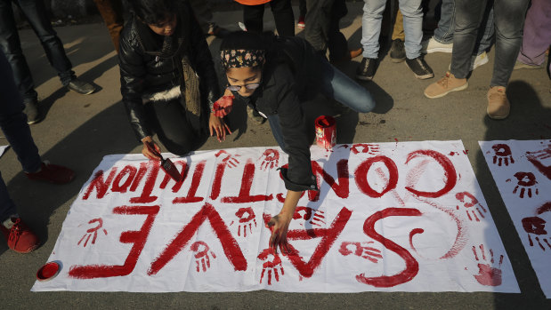 Indian students of Jamia Millia Islamia University prepare banners  during a protest against the law.