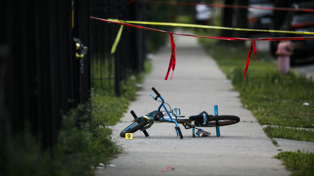 Evidence markers sit at the scene where a boy was killed after being shot in the abdomen while riding his bike in Chicago on the weekend.