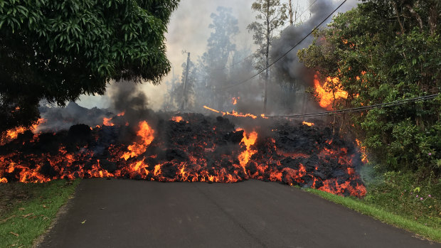 A lava flow from the erupting Kilauea volcano moves down a street in Hawaii's Leilani Estates. 