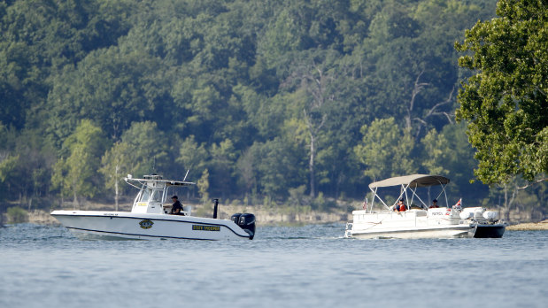 Emergency workers patrol an area on Friday near where the boat capsized.