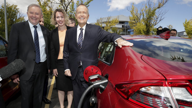 Anthony Albanese, Labor candidate for Canberra Alicia Payne and Bill Shorten view an electric car at a charging station.