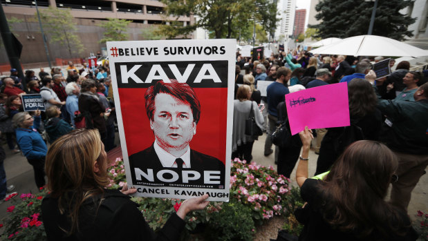 A woman holds a placard during a protest against the nomination of Brett Kavanaugh for the Supreme Court, in Denver, Colorado.