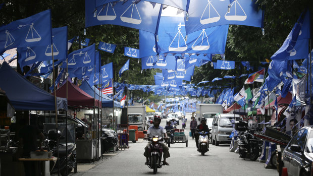 Flags from different political parties hang along a street in Kuala Lumpur.