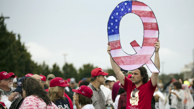 Trump supporter David Reinert holds a Q sign waits in line with others to enter a rally with President Donald Trump in Wilkes-Barre, Pennsylvania. 