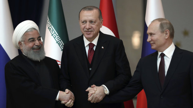 From left: Hassan Rouhani, Recep Tayyip Erdogan and Vladimir Putin, lock hands in Ankara, on Wednesday, .