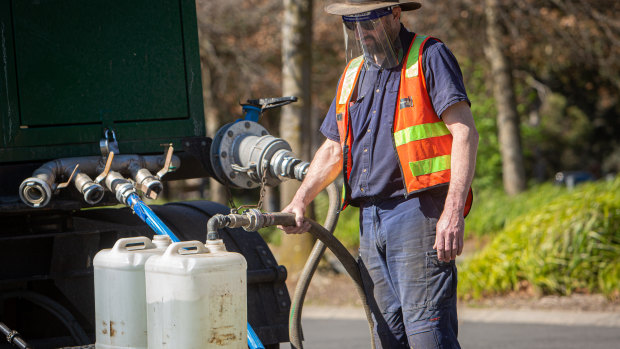 Residents collect clean drinking water from a tanker in the car park of the Ferntree Gully Arboretum on Saturday.