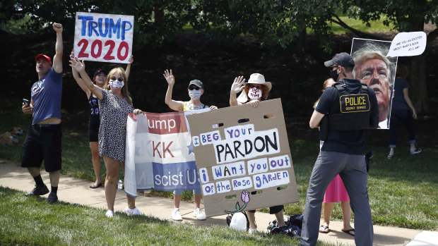 Protesters and supporters of President Donald Trump stand outside Trump National Golf Club in Sterling, Virginia on Saturday.