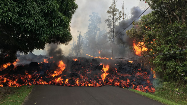 A lava flow from the erupting Kilauea volcano moves down a street in Hawaii's Leilani Estates. 