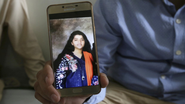 Texas high school shooting victim Sabika Sheikh's father with a  photo of his daughter. 